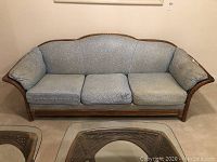 Front view of Lane sofa showing light blue fabric cushions and woven wood frame.