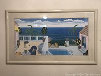 Full view of framed coastal landscape print on wall with visible reflection on glass