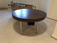 Round bumper pool table measuring approximately 48 inches in diameter showing the metal legs and wooden edge frame.