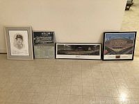 Four framed baseball prints displayed on floor including portrait of Billy Martin, Brooklyn Dodgers 1955 team photo, panoramic of Camden Yards, and Ebbets Field print.