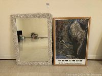 Full view of the shell motif wall mirror and framed Chesapeake Bay satellite photo poster.