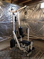 Three-quarter front view of the full gym machine in unfinished basement