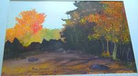 Close-up photo of watercolor painting showing vibrant fall trees and rocks with artist signature Ron Zahoruk