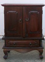 Front closed view of the wooden jewellery box with two doors and footed base.