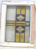 Front view of stained glass window in white wooden frame showing overall design and condition.