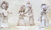 Three ceramic Dino Bencini figurines displayed on a fabric surface: 'The Gardener' holding a watering can and flowers, 'The Bride & Groom' couple with flowers, and 'The Photographer' with a large camera.