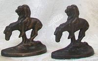Pair of bronze patinated cast iron bookends showing Native American figure on horseback front view.