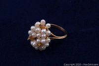 Ring on dark background showing overall cluster of pearls and gold leaves