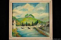 Front view of the framed oil on board landscape painting showing the river, bridge, castle on hill, trees, houses, and sky