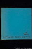 Front cover of A Prairie Boy's Winter book, blue cloth hardcover with title and small illustration on front.