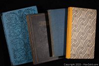 Four vintage books in varying sized hardcovers with wear visible on all