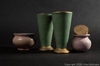 Photo showing two vintage celadon green goblets with gold rims and bases with two small rounded pottery pots, one pink with cork and one blue/multicolor, all signed.