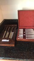 Four butcher knives by Marble Head with dark handles in a wooden box