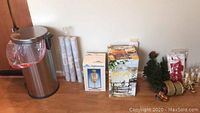 Entire lot on floor showing trash can, two boxed items (coach light and beverage dispenser), and Christmas decorations