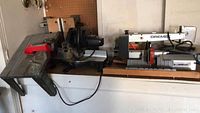 Photo showing a Dremel scroll saw, professional miter saw, grinder, router table, and clamp table.