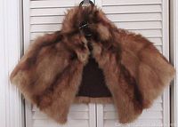 Front view of the brown fur capelet hung on a hanger against shuttered background