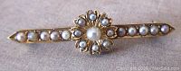Front view of vintage 14K yellow gold bar pin with seed pearls and central cultured pearl in flower cluster design.