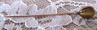 Full length view of the stick pin on lace background showing its length and gemstone detail.