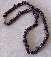 Full view of garnet chip necklace laid out to show length and chip details