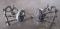 Front view of the pair of small silver bagpipe earrings showing detailed design and screw back style