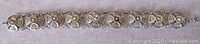 Full length view of the vintage silver filigree link bracelet laid flat, showing all nine circular links and spring ring clasp.