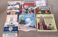 Photo showing View-Master reels and booklets including Snow White, Little Red Riding Hood, Cinderella, Mickey Mouse, Casper, Hansel and Gretel, Three Little Pigs, Queen Elizabeth (1953), and more.