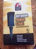 Box front showing Harbor Lights Outdoor Power Stake with 15 foot extension cord and features listed