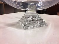 Close-up image of the bowl's heavy heavy stepped square base showing clear crystal and geometric cuts, highlighting craftsmanship and weight.