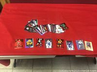 Lot of various NHL hockey insert cards laid out on table with some cards folded and grouped in the background.