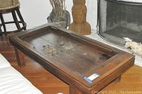 Full side angle view showing the rectangular wooden coffee table with block feet and carved edges.