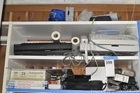 Overall view of shelving with all included items - fax machine, DVD player, paper packs, and cables
