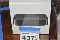 Front view of the unopened Apple TV retail box showing the device image.