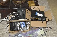 Overall view of lot showing woven basket of cables, cardboard box with preamplifier and cables, Ziploc bags and tools on floor