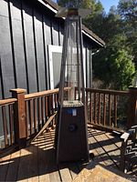 Full view of the outdoor pyramid patio heater positioned on a wooden deck.