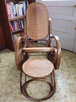 Full view of the bentwood rocker chair with matching foot stool, showing the curved wooden frame and cane weaving on both seats.