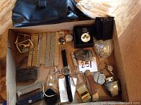 Box containing all lot items including watches, bands, knife, and accessories
