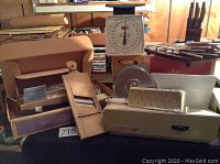 Wide view of kitchen tools showing vintage scale, knives, and slicers.