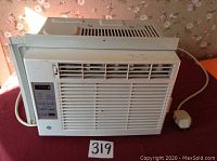 Full front view of the GE window air conditioner unit showing the air vents, digital control panel, and power cord.