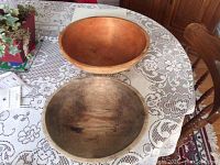 Top view of two wooden bowls on a lace tablecloth; one large light brown bowl, one smaller darker bowl