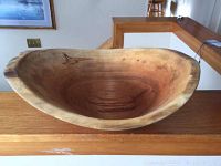 Front side view of the primitive hand carved wooden dough bowl showing interior, natural wood grain and wear.