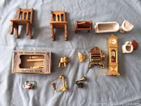 Photo of all miniature doll house furniture items displayed on fabric backdrop.