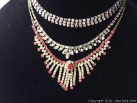 Front view of the three rhinestone necklaces displayed on a black bust, showing arrangement and design details