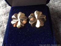 Front view of the pair of vintage 9ct gold clover-shaped stud earrings displayed on a blue velvet-covered box.