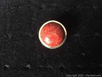 Top view of sterling silver ring with round red stone.