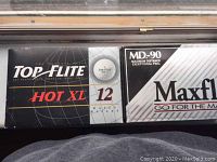 Top Flite Hot XL and Maxfli MD-90 golf ball boxes side by side showing packaging and branding