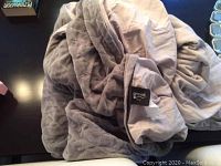 Grey quilted weighted blanket by Gravid, showing label and texture.