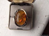 Top view of vintage sterling silver ring with large amber stone in original ring box.