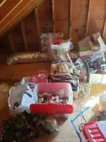 Photo of bins and boxes containing ribbons, gift bags, gift boxes, and Christmas ornaments stacked in an attic space