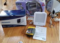 Photo of all items on table showing Bessel Spot Lifter, Panasonic stapler, Verilux HappyLight, Sony Sports Walkman, Bonjour Primo Latte frother and mirror