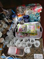 Image showing arranged kitchenware including glass salt and pepper chasers, white ceramic cups, glass jars, and plastic trays.